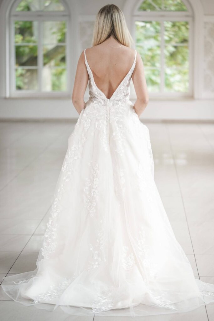 Tył minimalistycznej sukni ślubnej Alice - głębokie wycięcie w kształcie V aż do pasa, eleganckie wykończenie
