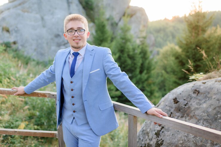 Garnitur BLUE – jasnoniebieski garnitur ślubny trzyczęściowy z jednorzędową kamizelką, biała koszula, granatowy krawat i poszetka (stylizacja)